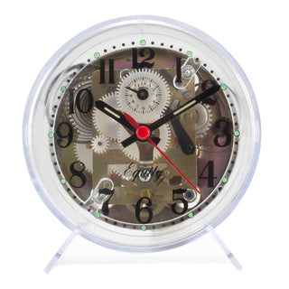 A round mechanical desk clock with a transparent outer shell, showcasing intricate gears and cogs inside. The clock face features black Arabic numerals, black hands, and a prominent red second hand.