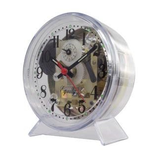 A transparent acrylic desk clock with a visible mechanical gear movement inside, black Arabic numerals, black hands, and a red second hand, standing on a clear plastic base against a white background.