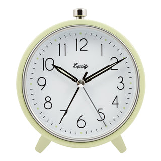 A retro-style round analog desk clock with a pale yellow-green frame, white face, black numerals and hands, and small silver accents including a top button and center pin. The brand name 'Equity' is printed on the clock face.