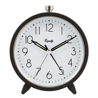 A classic round analog desk clock with a black metal frame, white face, black numerals and hands, and a silver top button. The brand name 'Equity' is printed on the clock face.