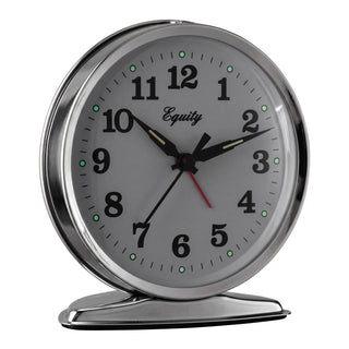 Right-facing image of the 24014 Analog Wind-Up Loud Bell Alarm Clock shown with dim lighting with the luminous hour dots glowing. The clock features a chrome case with a white dial, black numbers and hands, luminous hour and minute hands, luminous hour dots, and a red alarm indicator. The 'Equity' brand logo is printed in black script on the clock face.