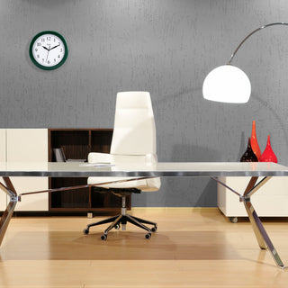 Lifestyle image of the 25205 10-inch Basics Wall Clock - Hunter Green shown hanging on an office wall. The clock features a hunter green frame with a white dial, black numbers, and black metal hands.