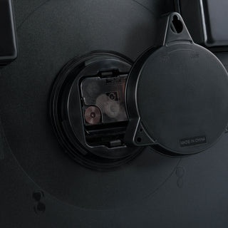 Weather-resistant battery cover  half off on the back of the 403-3246BR Lighted Lux 18-inch indoor outdoor wall clock displaying the protected battery compartment and quartz movement