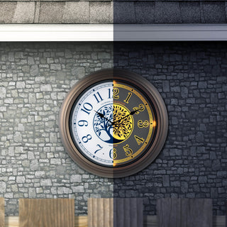 Outodor scene of the 403-3246BR Lux lighted indoor outdoor wall clock featuring a center image of a tree and Arabic numbers on a white and blue dial surrounded by a brown frame displaying the left half of the clock with no glow and the right half of the clock with the glow light function