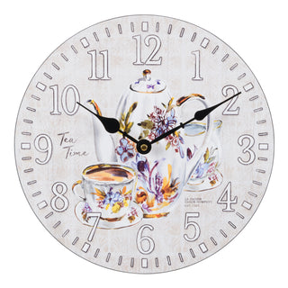 Head-on image of the 404-2631T 12-inch Teatime Wall Clock. The clock features an image of a floral teapot and teacup on a light-textured background, with the text "Tea Time," white numbers, black metal hands, and an open face design.
