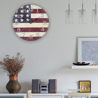 Round clock with American flag design hanging on a wall. 