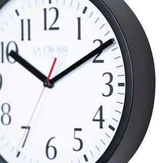 Close-up frame image of the 404-3020B 8-inch Basics Analog Wall Clock – Black. The clock features a black flush-mount frame, a white dial with black numbers, black hour and minute hands, and a red second hand.