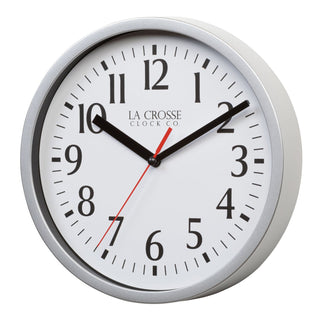 Left-facing image of the 404-3020S 8-inch Basics Analog Wall Clock – Silver featuring a silver flush-mount frame, a white dial with black numbers, black hour and minute hands, and a red second hand.