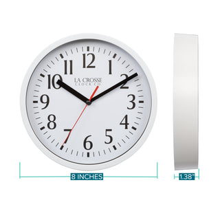 Dimension image in inches and centimeters of the 404-3020W 8-inch Basics Analog Wall Clock – White featuring a white flush-mount frame, a white dial with black numbers, black hour and minute hands, and a red second hand. The clock is 8.0 inches in diameter and 1.38 inches deep.