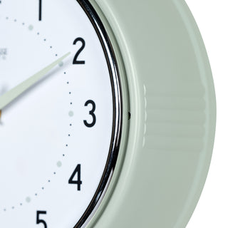 Close-up frame image of the 404-3024PH 9.5-inch Diner Wall Clock - Pistachio. The clock features an off-white dial with black numbers, pistachio hour dots, pistachio hour and minute hands, and a silver accent second hand set within a vintage-retro pistachio green frame.