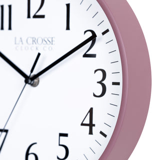 Close-up image of the Ruby Red Rose frame of the 404-3025RR 10-inch Basic Decor Wall Clock with a white dial,  black numbers, hour, minute, and second hands