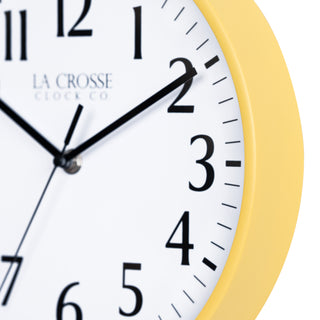 Close-up image of the Yellow frame of the 404-3025Y 10-inch Basic Decor Wall Clock with a white dial, black numbers, hour, minute, and second hands.