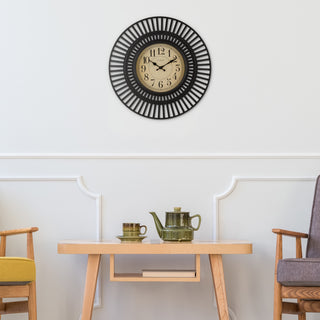 Lifestyle image of the 404-3051 20-inch Covington Wall clock hanging on a white wall with wainscotting and mid-century modern chairs and side table with an Asian influence designed teapot and cup