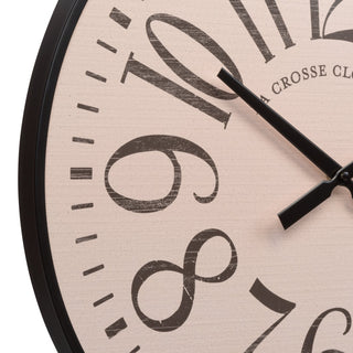 Close-up of a round wall clock with a light beige distressed face, large black numerals, black hands, and a black frame edge on a white background.
