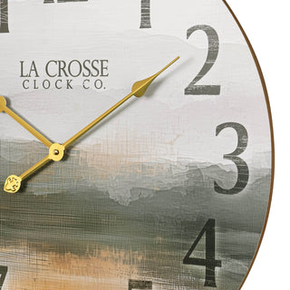 Close-up image of the dial detail of the 404-3461 24-inch Daybreak Wall Clock featuring an open face design of an impressionistic sunrise in muted tones, distressed numbers, and gold metal hands.