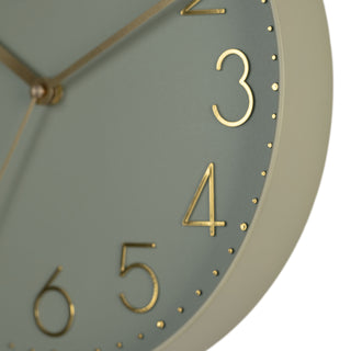Close-up image highlighting the frame of the 404-3831G 12-inch Paxton Wall Clock - Green, with Silent Sweep, featuring a flush-mount green frame, a matching color dial, brass raised numbers, and brass-finished hour, minute, and second hands.