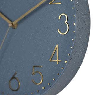 Close-up image highlighting the frame of the 404-3831SP 12-inch Paxton Wall Clock - Speckled, with Silent Sweep, featuring a flush-mount speckled blue frame, a matching color dial, brass raised numbers, and brass-finished hour, minute, and second hands.