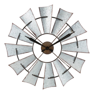 404-3956 A rustic metal windmill wall clock with distressed silver-gray blades and black hands, isolated on a white background.