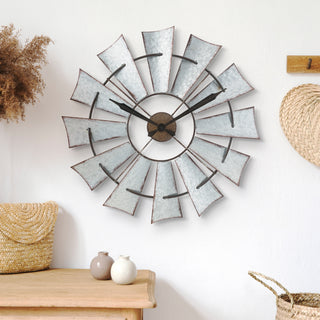 Windmill wall clock hanging with other decorative elements.