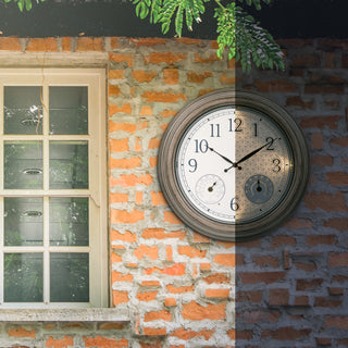 A round wall clock with a dark wood-look frame and white face is mounted on a brick wall beside a window. The right half of the wall is painted white, creating a split-color effect.