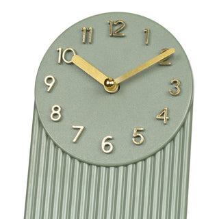 437-3015LS A modern wall clock with a muted sage green face and fluted lower body, featuring gold-tone Arabic numerals and hands on a white background.