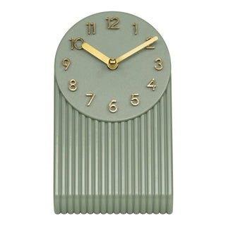 437-3015LS A modern wall clock with a muted sage green body, featuring a flared oval face with gold Arabic numerals and matching gold hands, set against a plain white background.